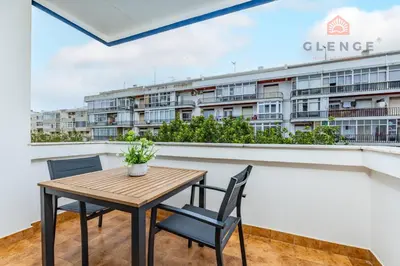 a table and chairs on a balcony with a building at Torre Mira Praia 2 Quartos by Glenge Holiday in Loulé