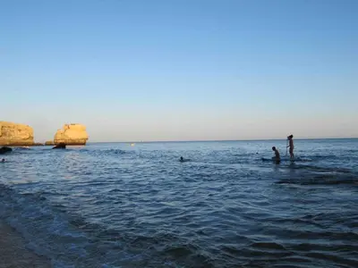 a group of people in the water at the beach at C Dreams - Comfortable and luminous apartment in Albufeira