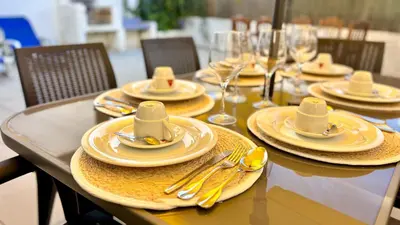 a table with yellow plates and silverware on it at Vilamoura Grand Terrace 2 by Homing in Vilamoura