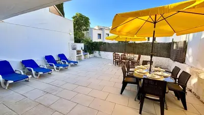 a patio with a table and chairs and a yellow umbrella at Vilamoura Grand Terrace 2 by Homing in Vilamoura