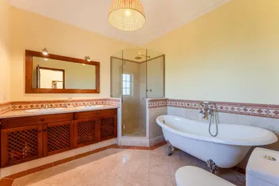 a bathroom with a tub and a sink and a mirror at Villa Serena in Almancil
