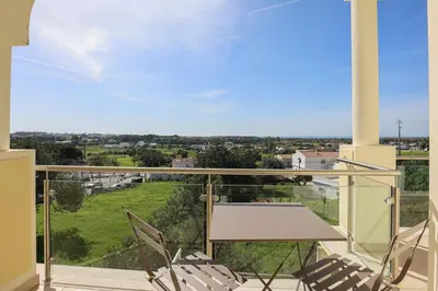 a balcony with chairs and a table and a view at Casa Ferreira - Encosta Vista Salgados - BY BEDZY in Guia