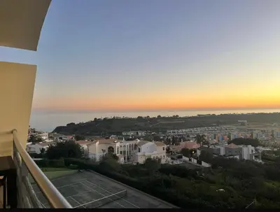 a view of a city at sunset from a balcony at E Orada sea view historic center tennis in Albufeira