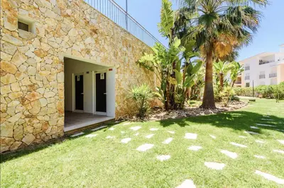 a stone house with a yard next to a building at E Orada sea view historic center tennis in Albufeira