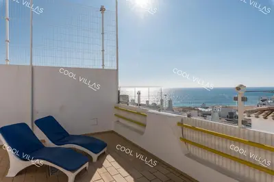 a balcony with two blue chairs and a view of the ocean at Apartamento Laurent - beachfront and city center in Albufeira