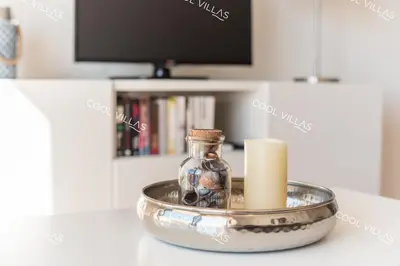 a glass bottle in a bowl with a candle on a table at Apartamento Laurent - beachfront and city center in Albufeira