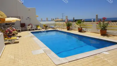 a hotel swimming pool on the roof of a building at Apartamento Laurent - beachfront and city center in Albufeira