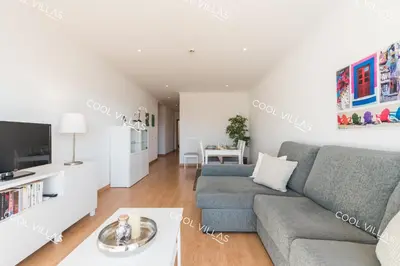 a living room with a couch and a tv at Apartamento Laurent - beachfront and city center in Albufeira