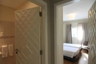 a bedroom with a bed and a sliding door at Apartamentos Valverde - Quinta do Lago in Quinta do Lago