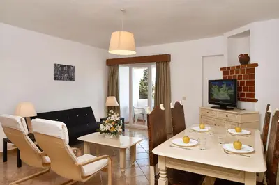 a living room with a white table and chairs at Cheerfulway Minichoro Apartamentos in Albufeira