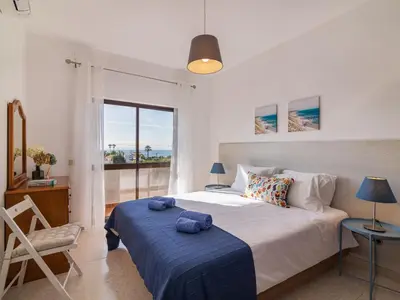 a bedroom with a large bed with a blue blanket at Villa Galé 600m from the beach by Interhome in Patroves
