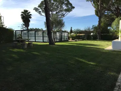 a park with a bench and a glass house at Vilamoura Villa Alegria in Vilamoura