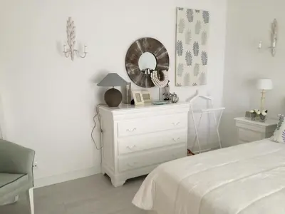 a white bedroom with a white dresser and a mirror at Vilamoura Villa Alegria in Vilamoura