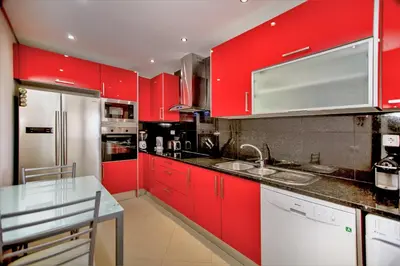 a kitchen with red cabinets and a white refrigerator at Villa Rafaella II Palace by Atlantic Places in Albufeira