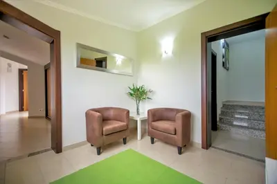 a hallway with two chairs and a table and a mirror at Villa Rafaella II Palace by Atlantic Places in Albufeira