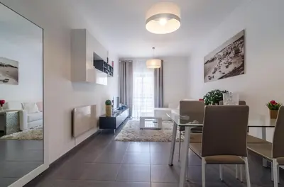 a dining room and living room with a table and chairs at Albufeira Oldtown 330ft Beach Parking AC Wifi in Albufeira