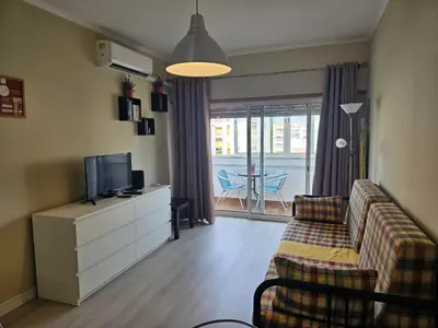 a living room with a couch and a tv at TMP Apartamento in Quarteira