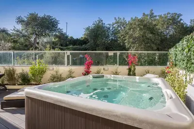 a jacuzzi tub on a patio with flowers at D_Loft Sea and Golf in Albufeira
