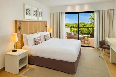 a deck with a chair and a swing at Pine Cliffs Ocean Suites, a Luxury Collection Resort & Spa, Algarve in Albufeira