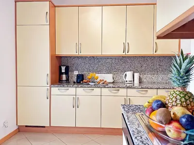 a kitchen with white cabinets and a bowl of fruit on a counter at Luxury Apartment Ocean View by Be Cherish in Páteo