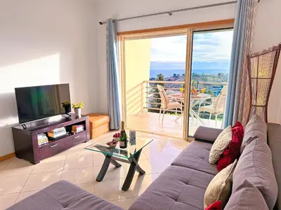 a living room with a couch and a television and a balcony at Luxury Apartment Ocean View by Be Cherish in Páteo