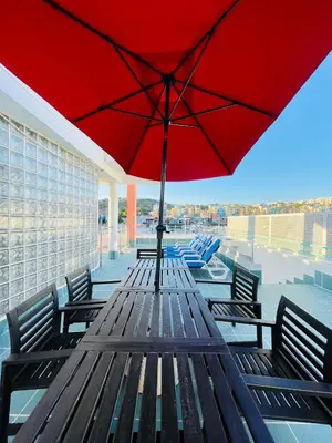 a picnic table with a red umbrella on a roof at Vila D'Alba - Sem Stress in Albufeira