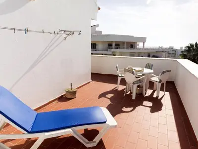 a patio with a table and chairs on a balcony at Vila Praia Apartment in Albufeira