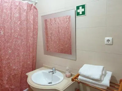 a bathroom with a sink and a red shower curtain at Albufeira Falesia Beach Apartment in Albufeira