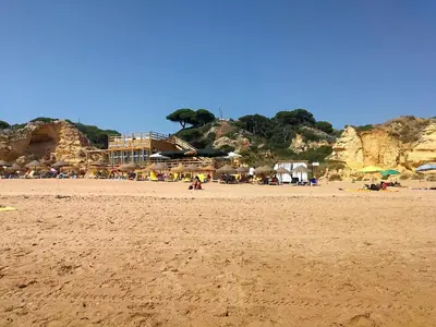 a beach with a group of people and umbrellas at Vista Mar Apartamento in Albufeira