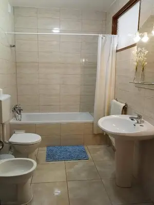 a bathroom with two sinks and a tub and a toilet at Vista Mar Apartamento in Albufeira