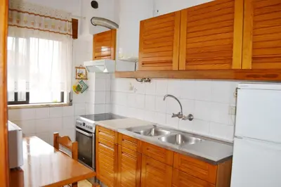a kitchen with wooden cabinets and a stainless steel sink at Vista Mar Apartamento in Albufeira