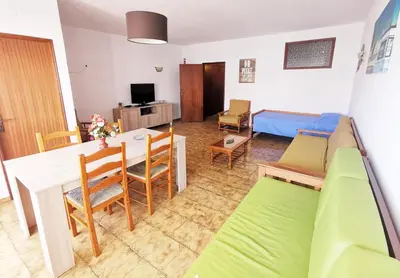 a living room with a table and a couch and a room at Vista Mar Apartamento in Albufeira