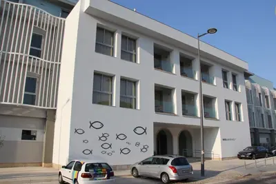 two cars parked in front of a white building at INATEL Albufeira in Albufeira