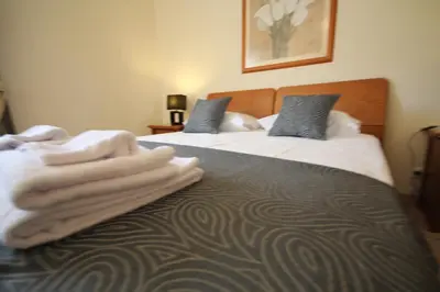 two beds in a hotel room with towels on them at Villa Fonte Santa in Quarteira