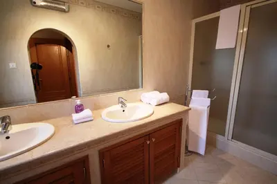a bathroom with two sinks and a large mirror at Villa Fonte Santa in Quarteira