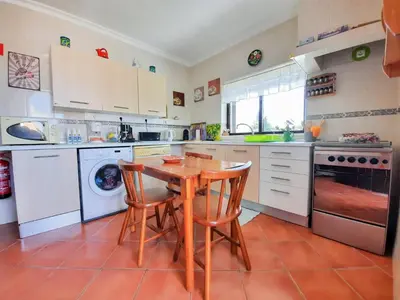 a kitchen with a wooden table and chairs in it at Villa Quinta do Algarve in Albufeira