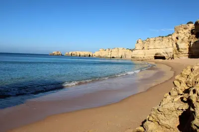 a sandy beach with rocks in the water at Villa Quinta do Algarve in Albufeira