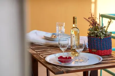 a wooden table with a bottle of wine and glasses at Apartment Orada Marina in Albufeira