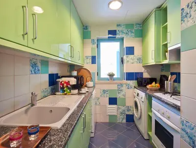 a colorful kitchen with a sink and a washing machine at Apartment Orada Marina in Albufeira