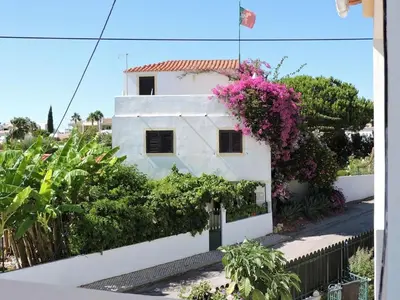 a white house with flowers on the side of it at Casa Portuguesa in Albufeira