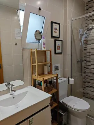 a bathroom with a sink and a toilet and a mirror at The Sunny Cottage by Freetimealgarve in Faro