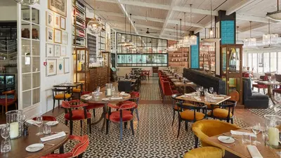 a restaurant with tables and chairs in a room at Blue&Greens Apartment in Quinta do Lago