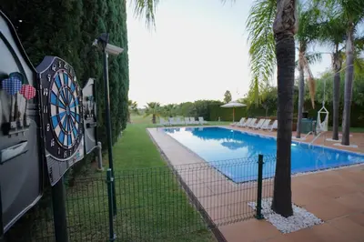 a dart board next to a swimming pool at Villa Laguna Golf-Frente ao laguna Golf in Vilamoura