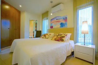 a bedroom with a white bed with a lamp and a window at Villa Laguna Golf-Frente ao laguna Golf in Vilamoura