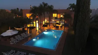 a swimming pool in front of a house at night at Villa Laguna Golf-Frente ao laguna Golf in Vilamoura