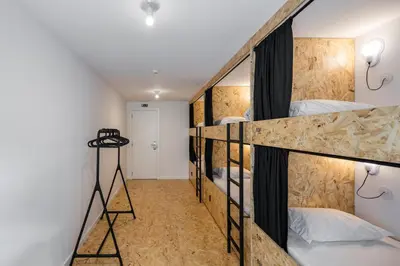 a room with four bunk beds in a building at Hostel Conii & Suites Algarve in Quarteira