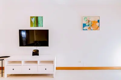 a living room with a white cabinet and a tv at AL- Apartamentos Novos Vista Mar in Quarteira
