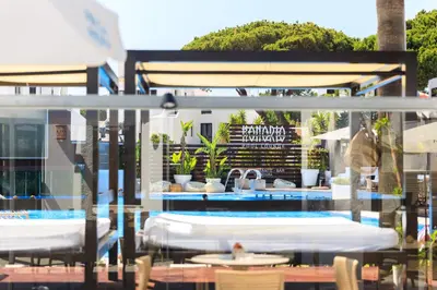 a swimming pool with a hotel bar with lights at Apartamentos Honorio - Pool and Garden in Vilamoura