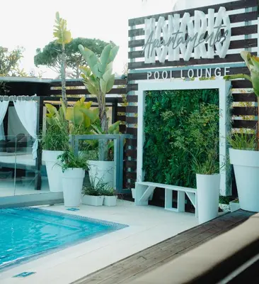 a large swimming pool with palm trees at night at Apartamentos Honorio - Pool and Garden in Vilamoura