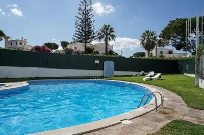 a large swimming pool in a yard with a fence at Akisol Vilamoura Star II in Quarteira